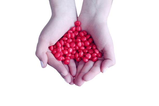 Red pills in hand transparent background PNG